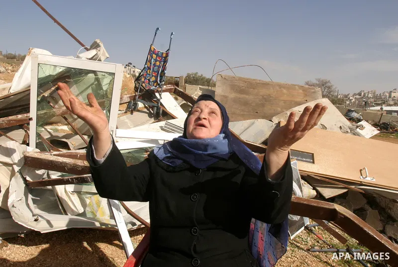 A Palestinian woman reacts after her house was demolished by Israeli bulldozers in the Arab east Jerusalem neighbourhood of Beit Hanina on February 9, 2012. Israel regularly demolishes homes in Arab east Jerusalem and th...