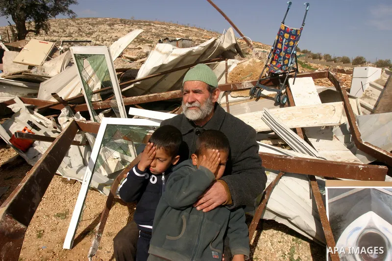 A Palestinian man sits with his grandchildren after their house was demolished by Israeli bulldozers in the Arab east Jerusalem neighbourhood of Beit Hanina on February 9, 2012. Israel regularly demolishes homes in Arab...