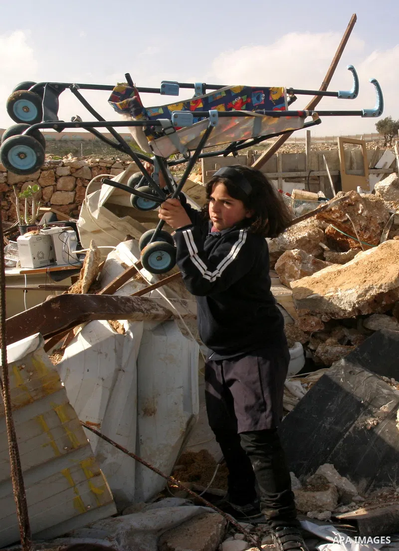 Palestinians collect their belongings after their house was demolished by Israeli bulldozers in the Arab east Jerusalem neighbourhood of Beit Hanina on February 9, 2012. Israel regularly demolishes homes in Arab east Jer...