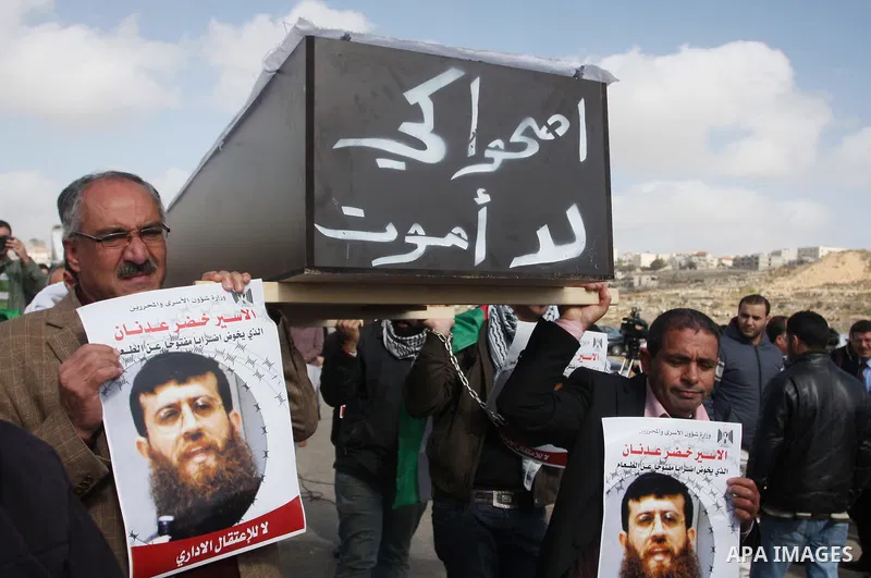 Palestinian protesters hold a mock coffin with the Arabic writing "wake up so that I will not die" as they demonstrate outside the Israeli Ofer military prison, near the West Bank town of Betunia, on February 9, 2012 aga...