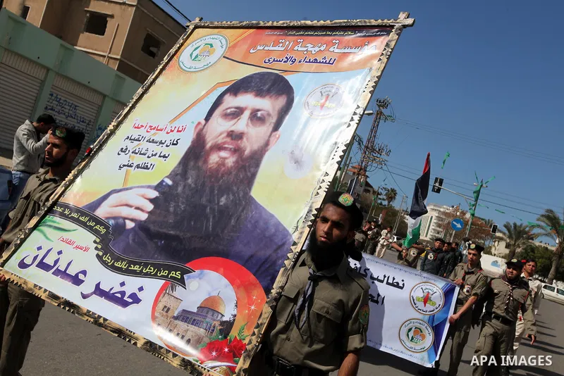 Palestinians scouts hold images of prisoner Khader Adnan, who has been on hunger strike since December 18 while being held in an Israeli jail, during a protest Gaza City, on Feb. 11, 2012. Photo by Majdi Fathi