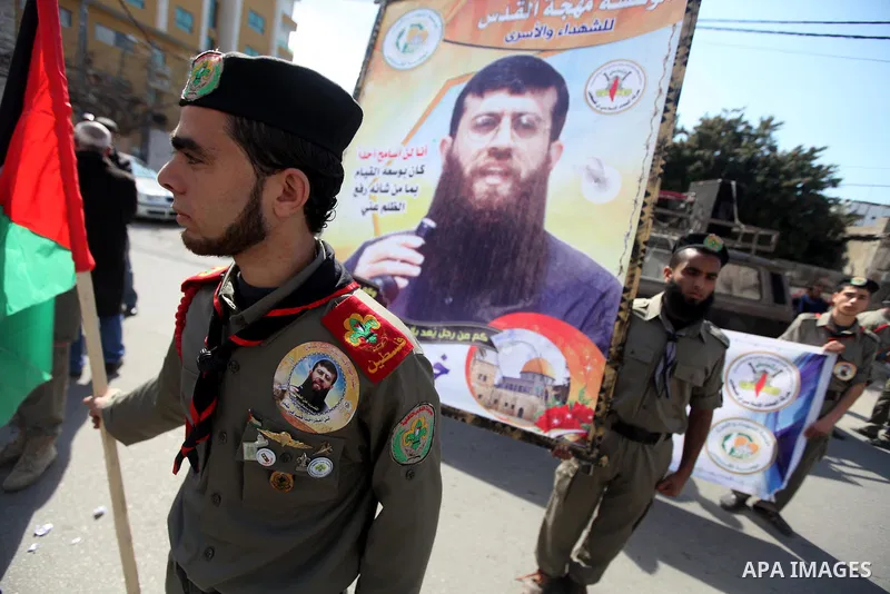 Palestinians scouts hold images of prisoner Khader Adnan, who has been on hunger strike since December 18 while being held in an Israeli jail, during a protest Gaza City, on Feb. 11, 2012. Photo by Majdi Fathi