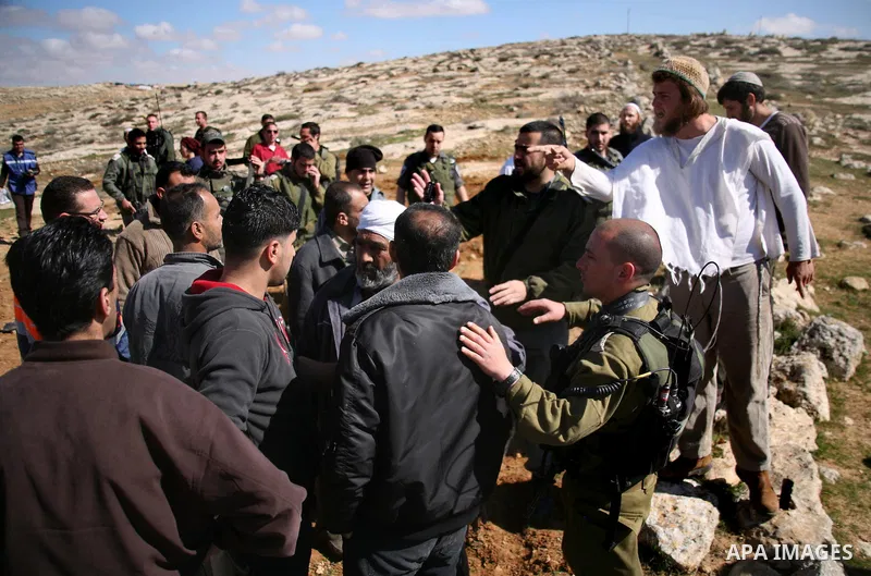 A Jewish settler from the Susia Israeli settlement argues with Israeli soldiers after a donkey was used by Palestinian farmers to transport trees to be planted on their land close to Susia village, in the Israeli occupie...