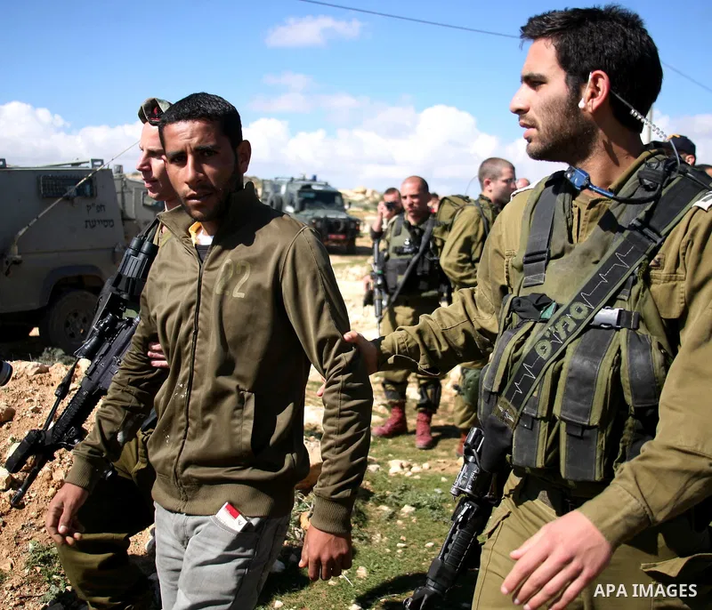 Israeli army forces arrest a youth during a raid in the Susia village, in the Israeli occupied West Bank on 11 February, 2012, as Israeli soldiers try to calm the situation. The European Union sees Israeli settlements in...