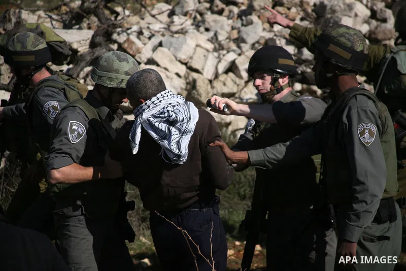 Israeli soldiers arrest a demonstrator during scuffles with Palestinians in a weekly protest against Israel's controversial separation barrier in the West Bank village of Beit Omar, close to city of Hebron and the settle...