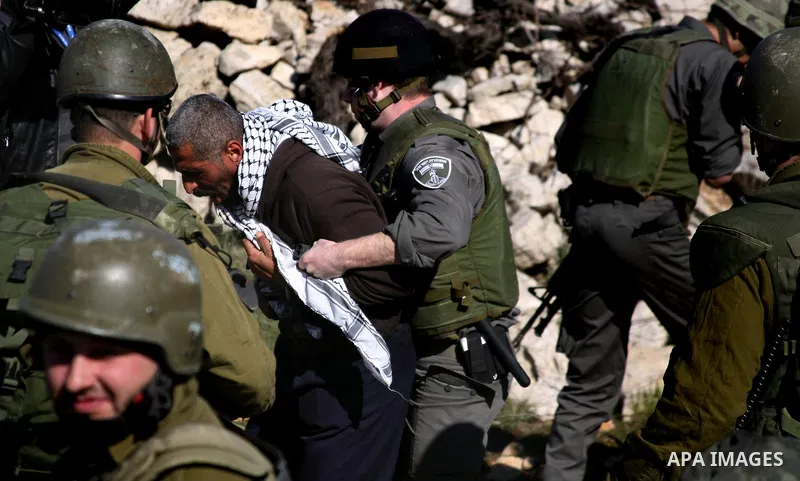 Israeli soldiers arrest a demonstrator during scuffles with Palestinians in a weekly protest against Israel's controversial separation barrier in the West Bank village of Beit Omar, close to city of Hebron and the settle...