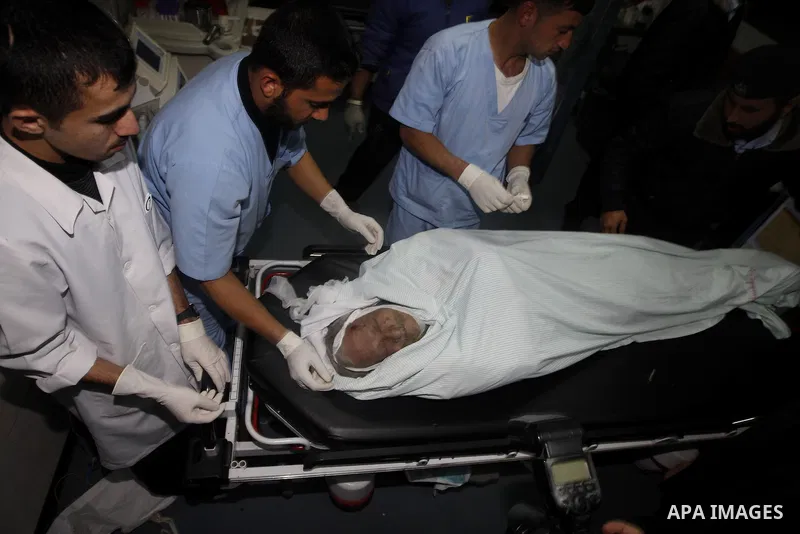 Palestinian medical workers examine the body of Abdelkarim Zaytoniya, a 75-year-old who was killed in Israeli aerial bombing, at al-Shefa hospital in Gaza City, Feb. 12, 2012. A Palestinian was killed and two others were...