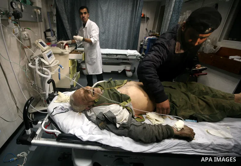 Palestinian medical workers examine the body of Abdelkarim Zaytoniya, a 75-year-old who was killed in Israeli aerial bombing, at al-Shefa hospital in Gaza City, Feb. 12, 2012. A Palestinian was killed and two others were...
