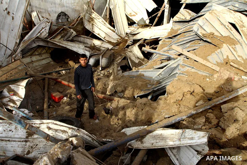 Palestinians inspect damages following Israeli air strikes in Gaza City on February 12, 2012. A Palestinian man died after being wounded in a series of retaliatory Israeli air strikes, Gaza medical sources said. Photo by...