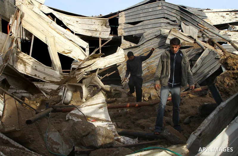 Palestinians inspect damages following Israeli air strikes in Gaza City on February 12, 2012. A Palestinian man died after being wounded in a series of retaliatory Israeli air strikes, Gaza medical sources said. Photo by...