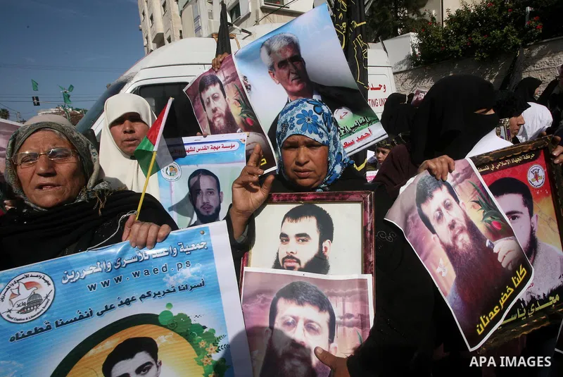 Palestinian women hold posters depicting Palestinian prisoner Khader Adnan, a member of the Islamic Jihad militant group, during a protest in Gaza City, calling for the release of Palestinian prisoners from Israeli jails...