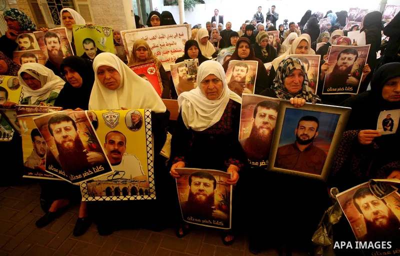 Palestinian women hold posters depicting Palestinian prisoner Khader Adnan, a member of the Islamic Jihad militant group, during a protest in Gaza City, calling for the release of Palestinian prisoners from Israeli jails...