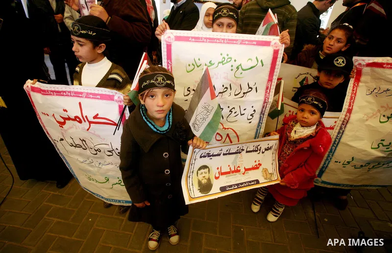 Palestinian women hold posters depicting Palestinian prisoner Khader Adnan, a member of the Islamic Jihad militant group, during a protest in Gaza City, calling for the release of Palestinian prisoners from Israeli jails...
