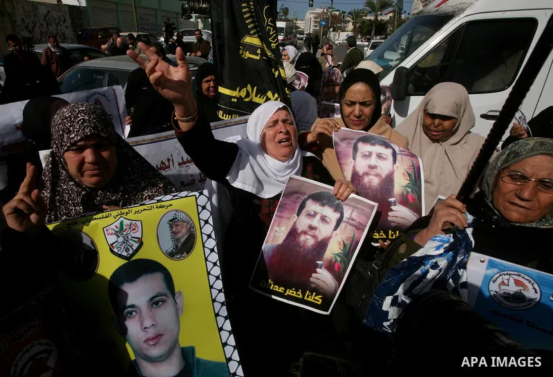 Palestinian women hold posters depicting Palestinian prisoner Khader Adnan, a member of the Islamic Jihad militant group, during a protest in Gaza City, calling for the release of Palestinian prisoners from Israeli jails...