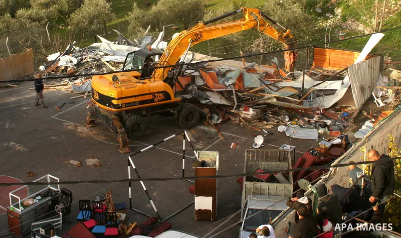 Israeli soldiers keep watch as a bulldozer demolishes on February 13, 2012 a Palestinian cbelonging to Jerusalem resident Ahmad al-Baghdadi that was built without the municipality's permission in the holy city's Arab nei...