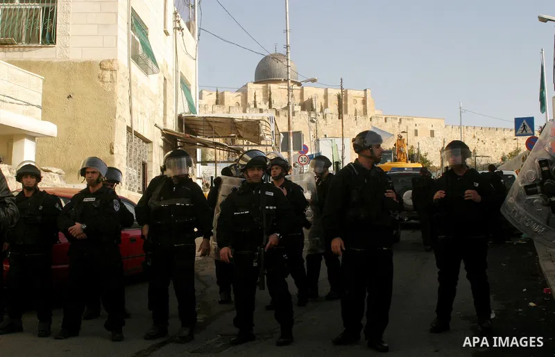 Israeli soldiers keep watch as a bulldozer demolishes on February 13, 2012 a Palestinian cbelonging to Jerusalem resident Ahmad al-Baghdadi that was built without the municipality's permission in the holy city's Arab nei...
