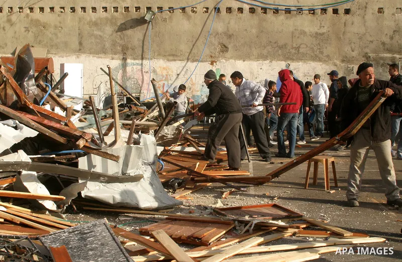 Israeli soldiers keep watch as a bulldozer demolishes on February 13, 2012 a Palestinian cbelonging to Jerusalem resident Ahmad al-Baghdadi that was built without the municipality's permission in the holy city's Arab nei...