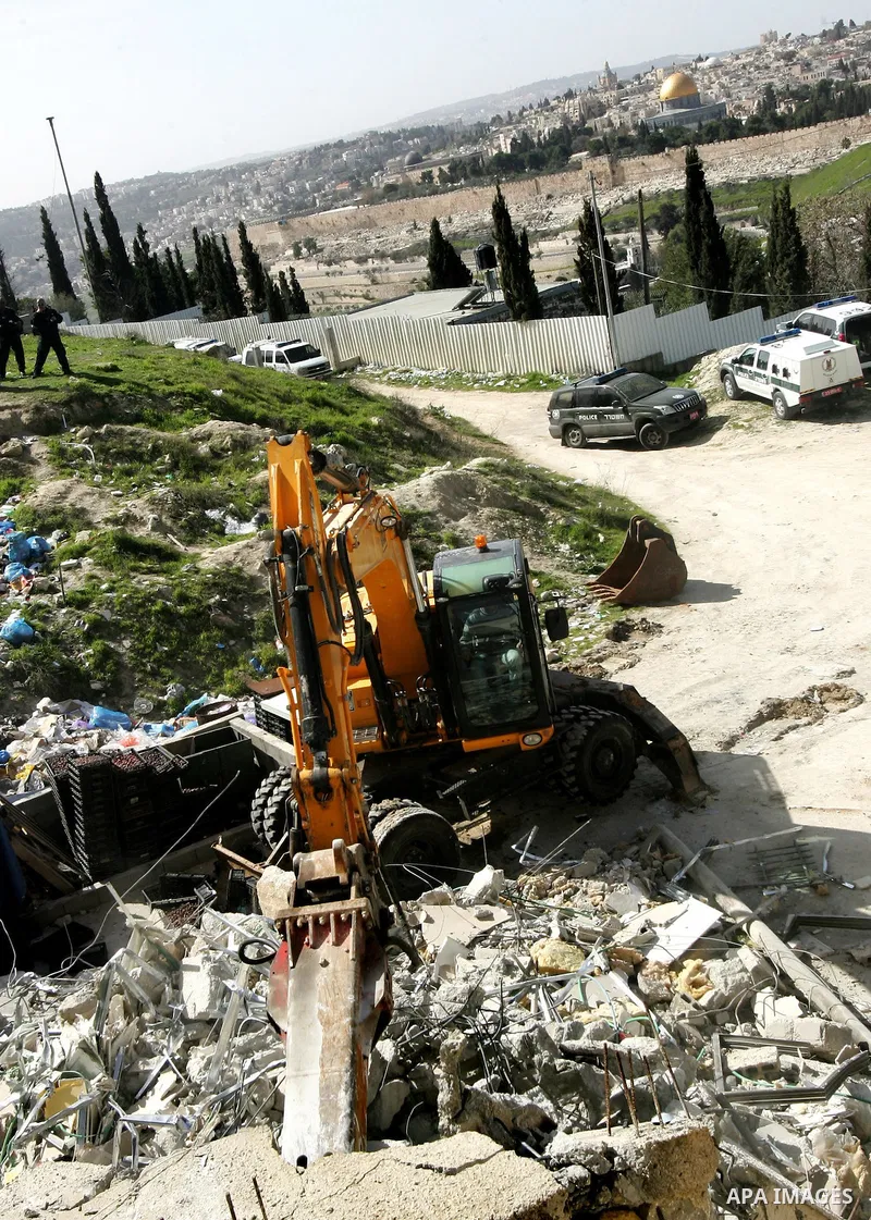 Israeli soldiers keep watch as a bulldozer demolishes on February 13, 2012 a Palestinian cbelonging to Jerusalem resident Ahmad al-Baghdadi that was built without the municipality's permission in the holy city's Arab nei...