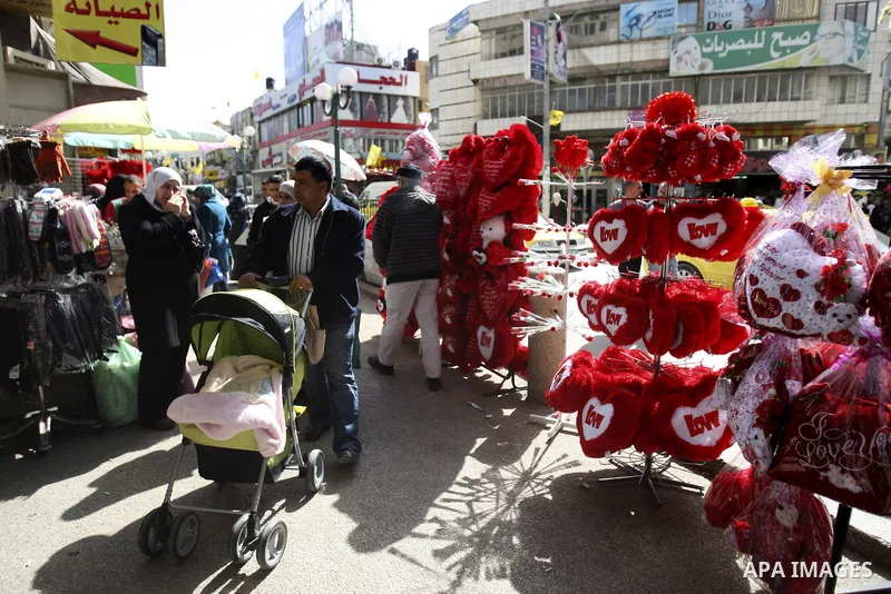 Palestinian man displays hearts in the shop to commemorate Valentine's Day adorned with sayings about love, in West Bank City of Nablus, on February 13, 2012. Valentine's Day is celebrated each year on 14 February. Photo...