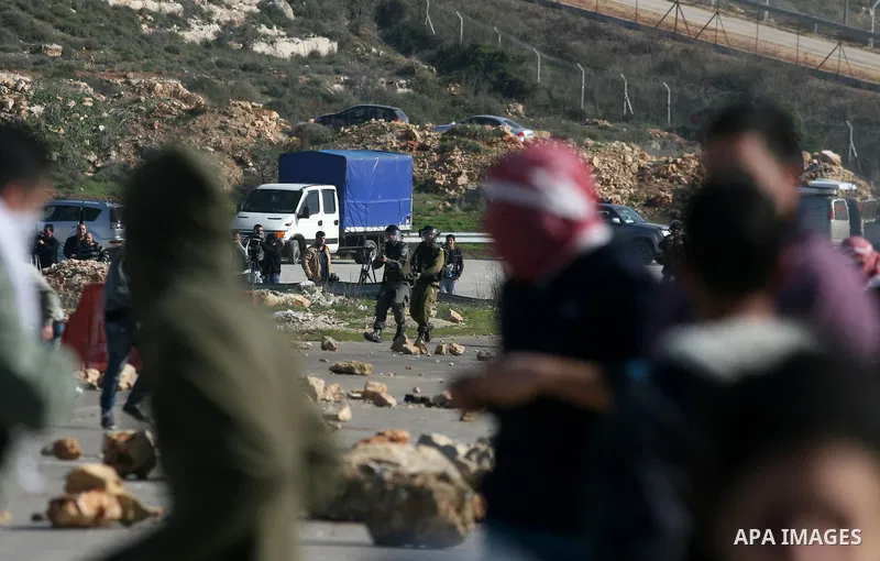 Palestinian protesters hurls stones at Israel security forces during clashes outside the Ofer military prison near the West Bank city of Ramallah, Monday, Feb. 13, 2012. Clashes between dozens of Palestinians and Israeli...