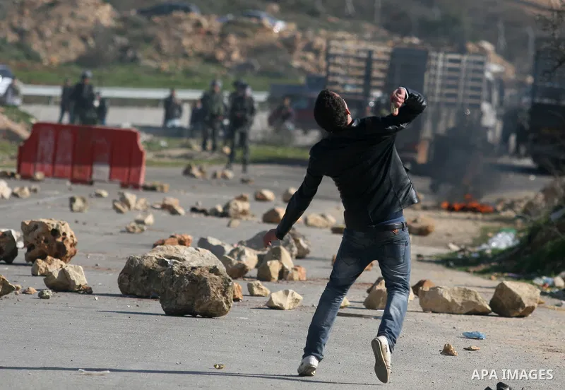 Palestinian protesters hurls stones at Israel security forces during clashes outside the Ofer military prison near the West Bank city of Ramallah, Monday, Feb. 13, 2012. Clashes between dozens of Palestinians and Israeli...