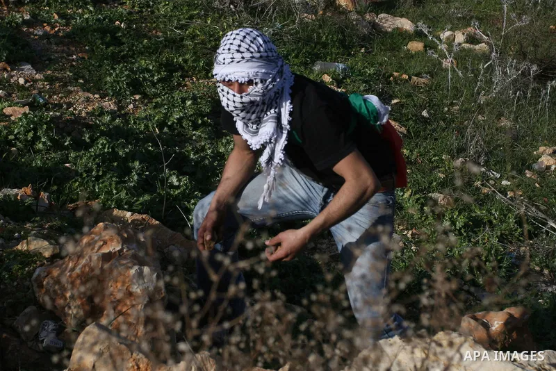 Palestinian protesters hurls stones at Israel security forces during clashes outside the Ofer military prison near the West Bank city of Ramallah, Monday, Feb. 13, 2012. Clashes between dozens of Palestinians and Israeli...