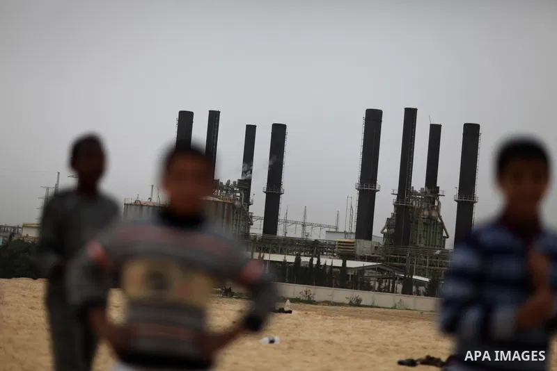 Palestinian boys play football in front of the power plant that generates electricity in Al-Nusirat in the central Gaza Strip, 14 February 2012. The Gaza Energy Authority said that the sole remaining power plant in the G...