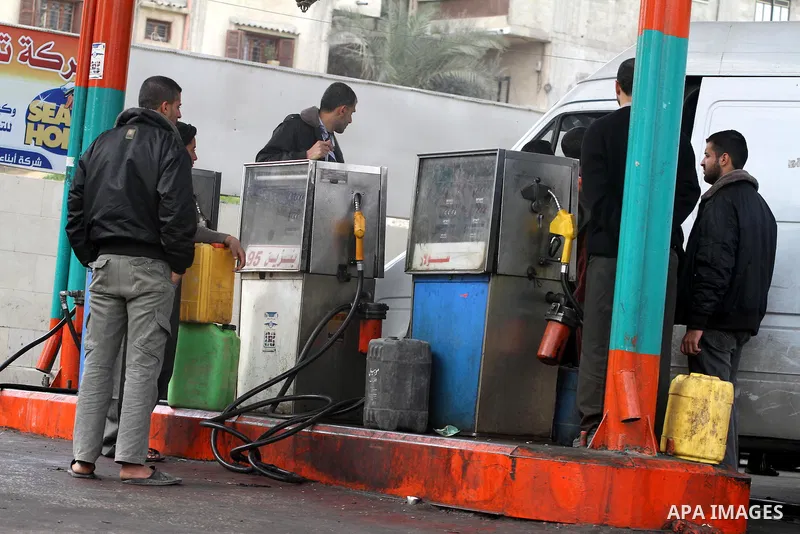 Palestinians wait to fill containers with fuel from a petrol station in Gaza City, on February 15, 2012, as the Palestinian authority calls on Egypt to provide more fuel. Photo by Mohammed Asad