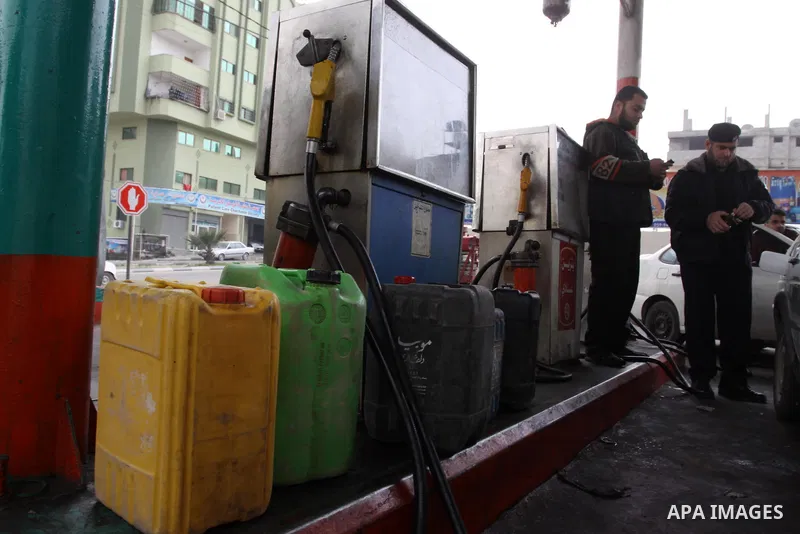 Palestinians wait to fill containers with fuel from a petrol station in Gaza City, on February 15, 2012, as the Palestinian authority calls on Egypt to provide more fuel. Photo by Mohammed Asad