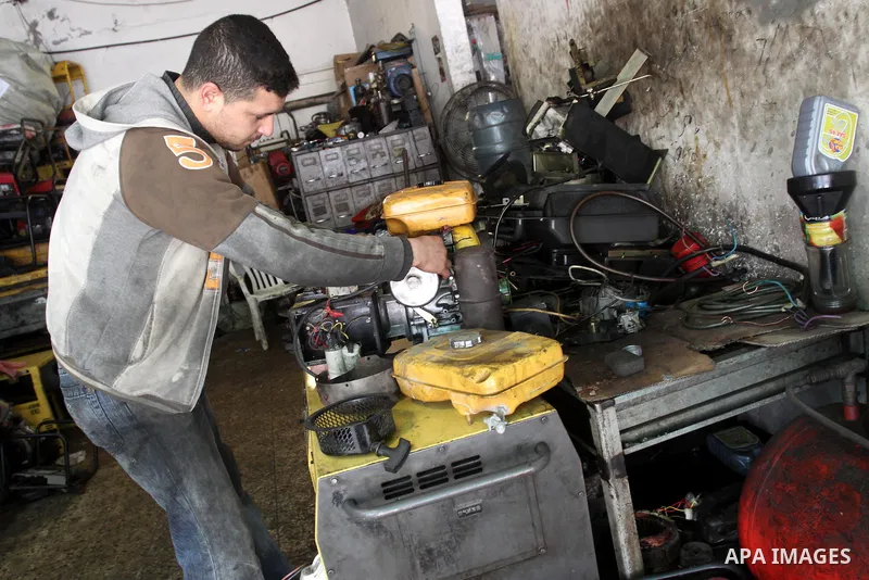 A Palestinian man fixes a generator at a shop in Gaza City, on February 15, 2012. The people of the Gaza Strip use a large number of generators because of the continuing lack of electricity in the Gaza Strip. Photo by Mo...