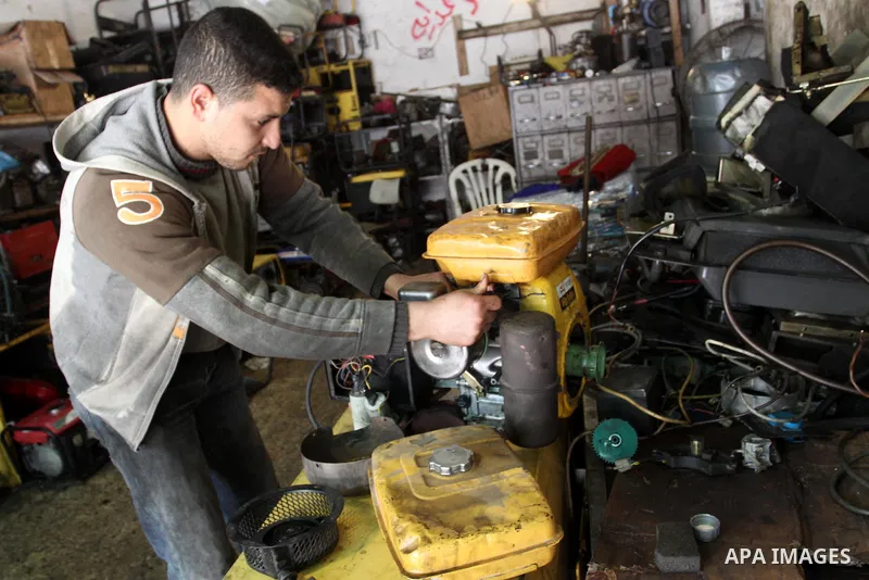 A Palestinian man fixes a generator at a shop in Gaza City, on February 15, 2012. The people of the Gaza Strip use a large number of generators because of the continuing lack of electricity in the Gaza Strip. Photo by Mo...