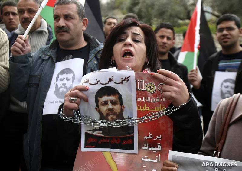 Palestinians hold up a pictures to Khader Adnan, 33, a jailed senior member of Islamic Jihad who has been on hunger strike for nearly 60 days days as they called for the release of Palestinian prisoners jailed in Israel,...