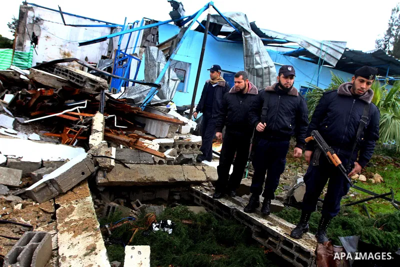 A Hamas police officer looks at the damage to a structure after an Israeli air strike in Gaza City February 16, 2012. The Israeli military said aircraft targeted two militant facilities early on Thursday in response to r...