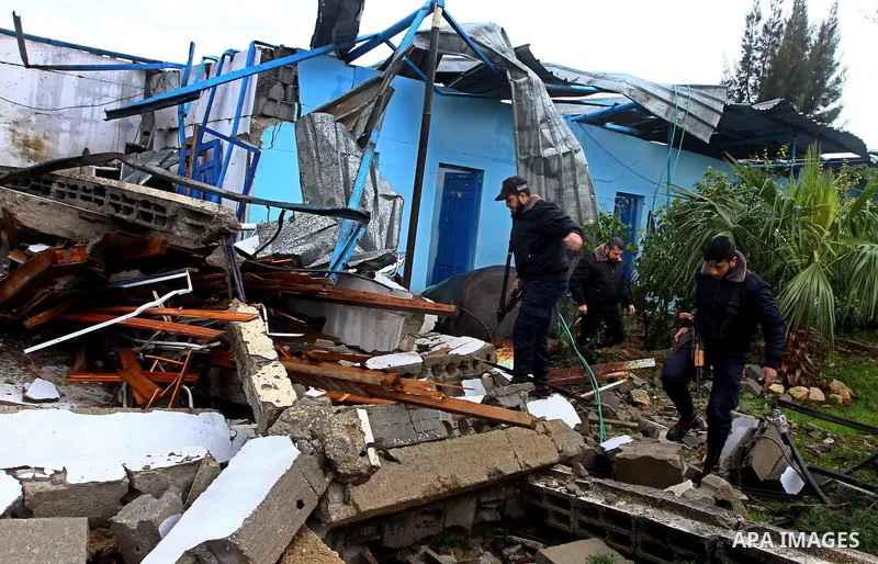 A Hamas police officer looks at the damage to a structure after an Israeli air strike in Gaza City February 16, 2012. The Israeli military said aircraft targeted two militant facilities early on Thursday in response to r...