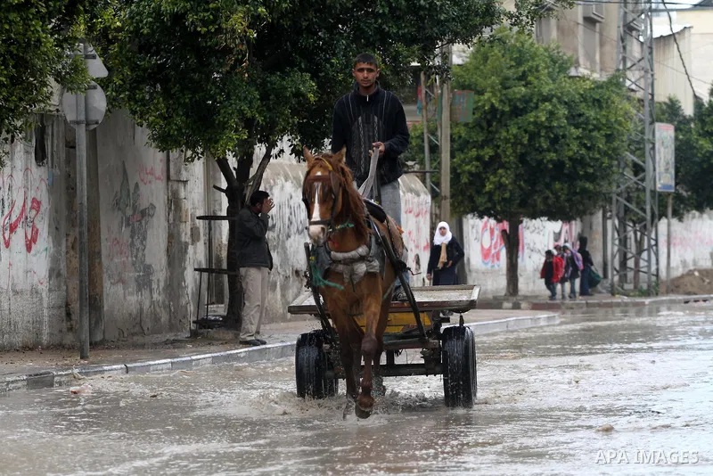 Palestinians drive their cars through a flooded street after heavy rain and cold winds, in the Gaza City, Feb. 16, 2012. Photo by Mohammed Asad