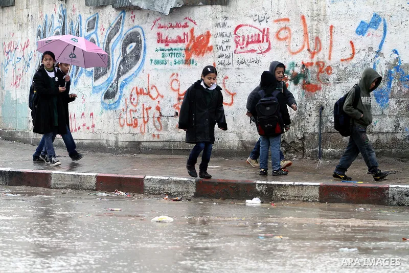Palestinian students stand in a street during the heavy rain of the winter, in the Gaza City, Feb. 16, 2012. Photo by Mohammed Asad