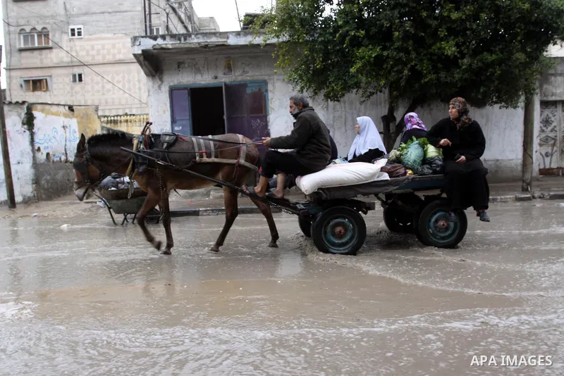 Palestinians drive their cars through a flooded street after heavy rain and cold winds, in the Gaza City, Feb. 16, 2012. Photo by Mohammed Asad