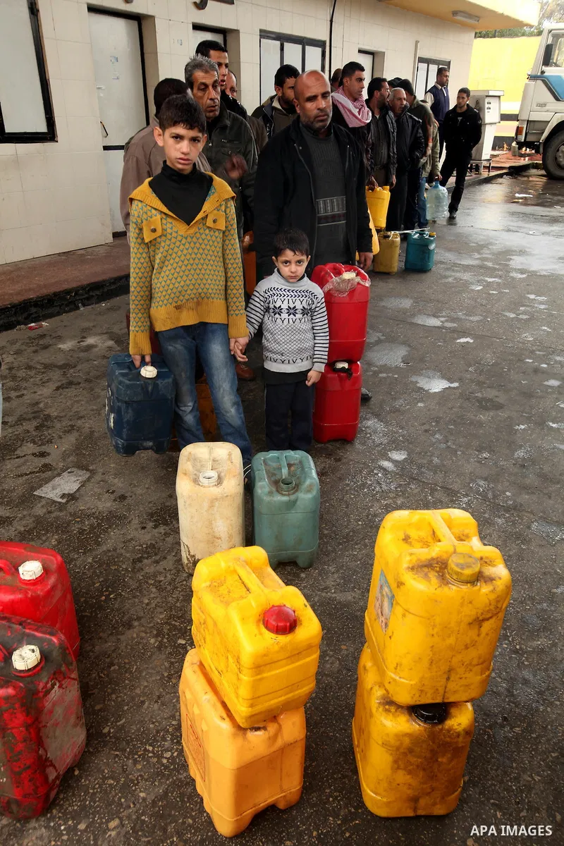 Palestinians fill containers with fuel from a petrol station in the Gaza City on 16 February 2012. Reports state that residents in the Gaza Strip flocked to petrol stations hoping to get a share of the remaining fuel, sa...