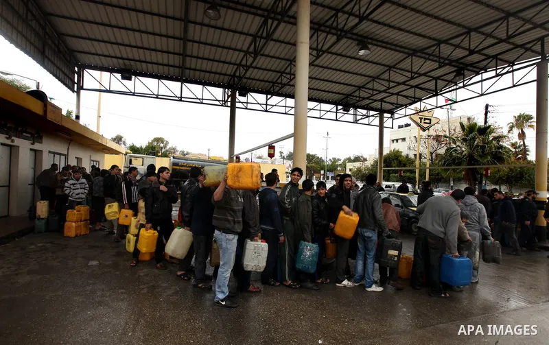Palestinians fill containers with fuel from a petrol station in the Gaza City on 16 February 2012. Reports state that residents in the Gaza Strip flocked to petrol stations hoping to get a share of the remaining fuel, sa...