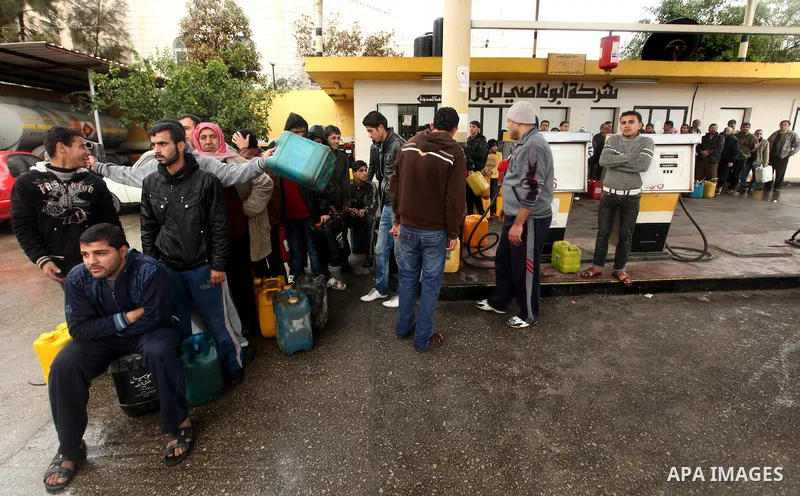 Palestinians fill containers with fuel from a petrol station in the Gaza City on 16 February 2012. Reports state that residents in the Gaza Strip flocked to petrol stations hoping to get a share of the remaining fuel, sa...