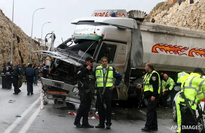 Israeli and Palestinian rescue workers stand with onlookers at the scene of an accident near the Qalandiya checkpoint outside the West Bank city of Ramallah February 16, 2012. At least five Palestinian children were kill...