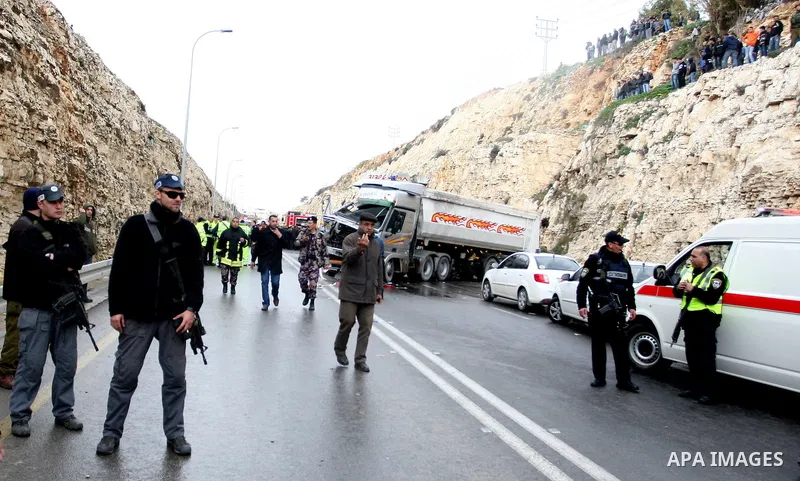 Israeli and Palestinian rescue workers stand with onlookers at the scene of an accident near the Qalandiya checkpoint outside the West Bank city of Ramallah February 16, 2012. At least five Palestinian children were kill...