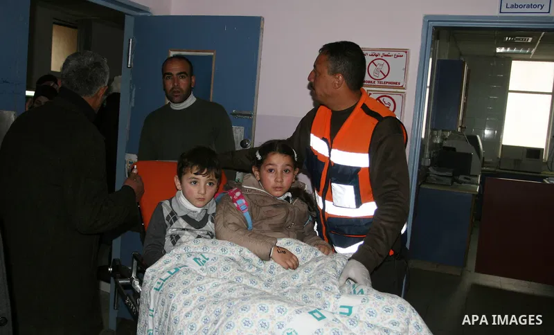 Palestinian paramedics transfer a wounded on wheel to the hospital, at the an accident near the Qalandiya checkpoint outside the West Bank city of Ramallah February 16, 2012. At least five Palestinian children were kille...