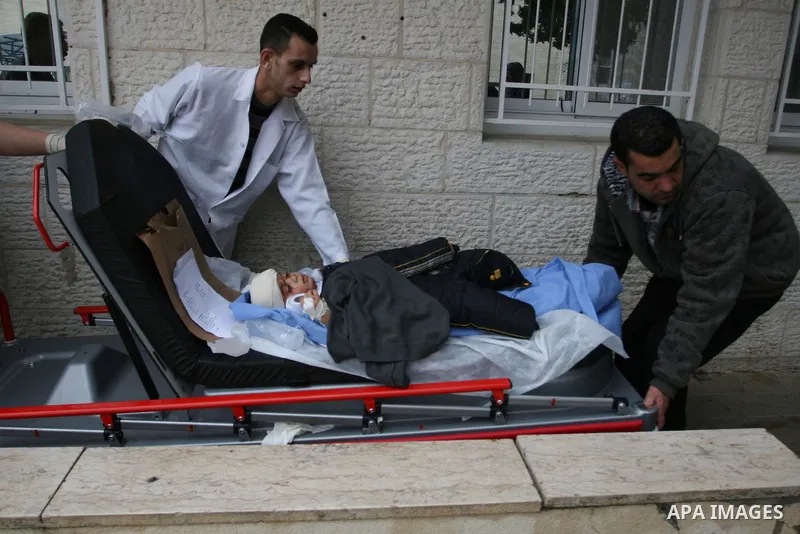 Palestinian paramedics transfer a wounded on wheel to the hospital, at the an accident near the Qalandiya checkpoint outside the West Bank city of Ramallah February 16, 2012. At least five Palestinian children were kille...