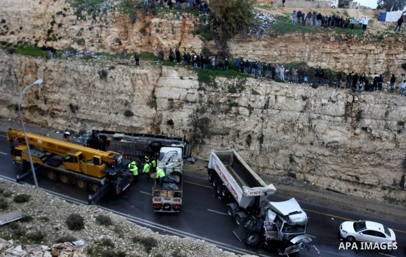 Israeli and Palestinian rescue workers stand with onlookers at the scene of an accident near the Qalandiya checkpoint outside the West Bank city of Ramallah February 16, 2012. At least five Palestinian children were kill...