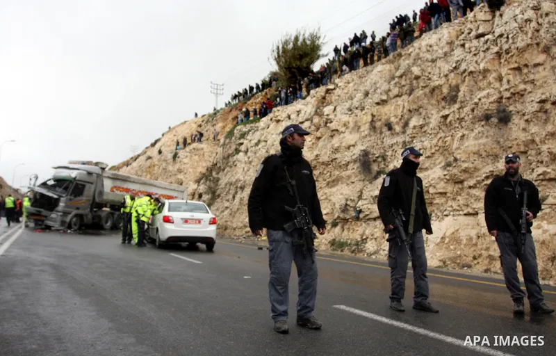 Israeli and Palestinian rescue workers stand with onlookers at the scene of an accident near the Qalandiya checkpoint outside the West Bank city of Ramallah February 16, 2012. At least five Palestinian children were kill...