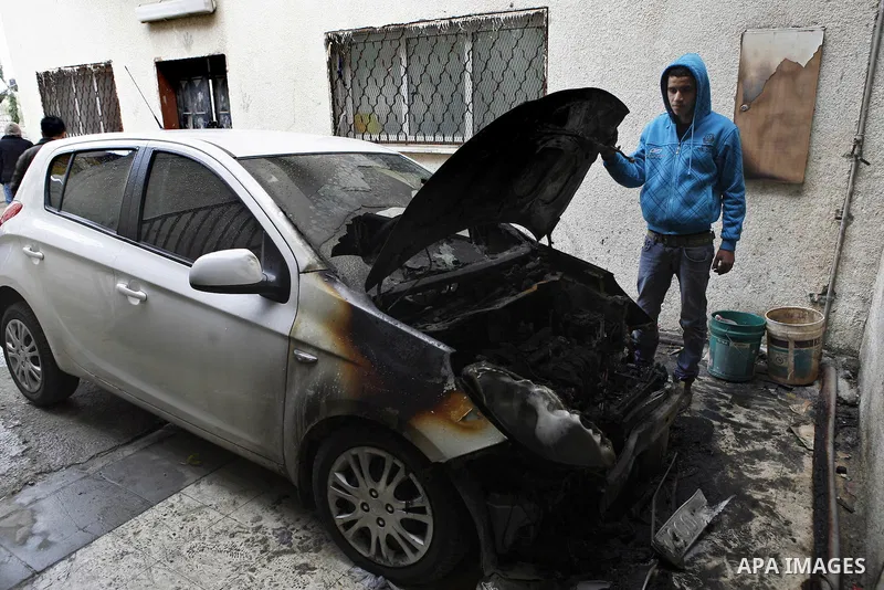 Palestinian shows his burnt car in the West Bank village of Nabi Elyas, near the West Bank city of Qalqilya , 16 Februray 2012. Right wing Israelis are suspected of having burned it. Police arrested an Israeli settler on...