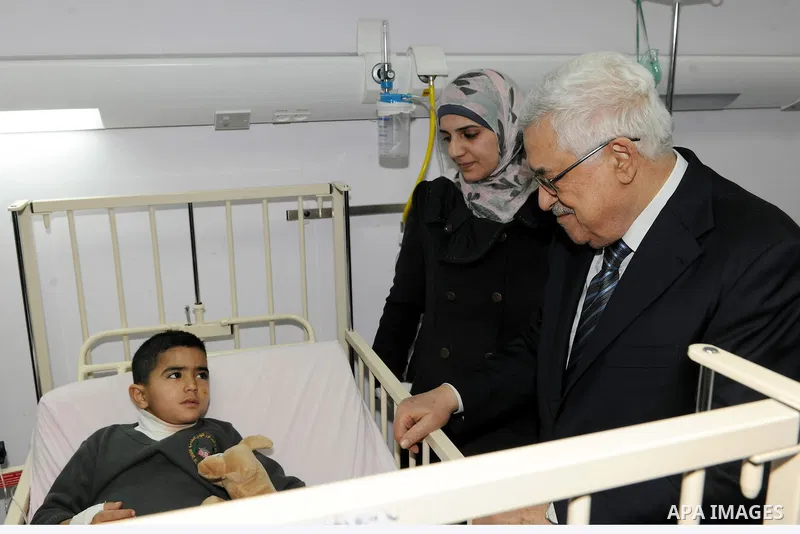 Palestinian President Mahmoud Abbas visits a Palestinian child, one of dozens of schoolchildren injured in a school bus accident, at a hospital in the West Bank city of Ramallah, Thursday, Feb. 16, 2012. A truck lost con...