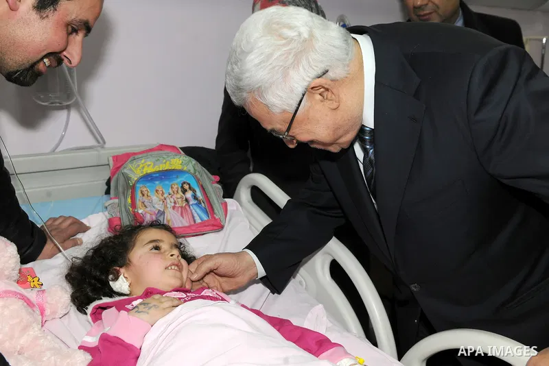 Palestinian President Mahmoud Abbas visits a Palestinian child, one of dozens of schoolchildren injured in a school bus accident, at a hospital in the West Bank city of Ramallah, Thursday, Feb. 16, 2012. A truck lost con...