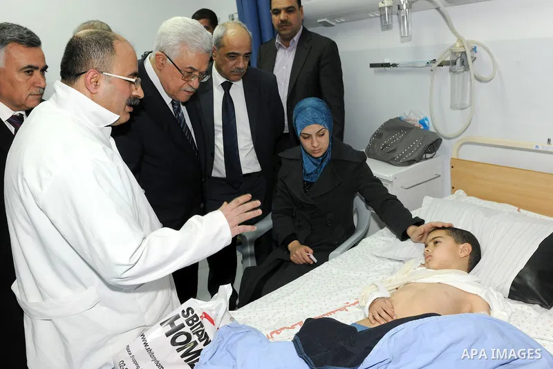 Palestinian President Mahmoud Abbas visits a Palestinian child, one of dozens of schoolchildren injured in a school bus accident, at a hospital in the West Bank city of Ramallah, Thursday, Feb. 16, 2012. A truck lost con...